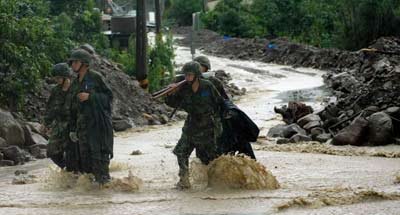 圖為救援官兵冒雨參與抗洪搶險(xiǎn)。